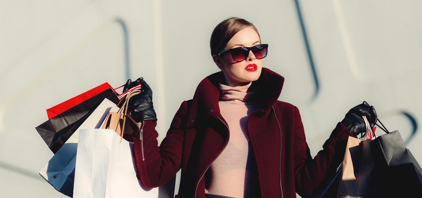 Woman carrying paper shopping bags outside an Astor Lane store